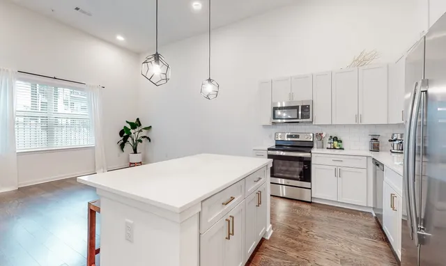 a kitchen with white cabinets and white appliances