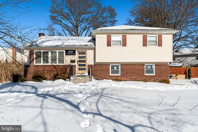 a front view of a house with a yard covered in snow