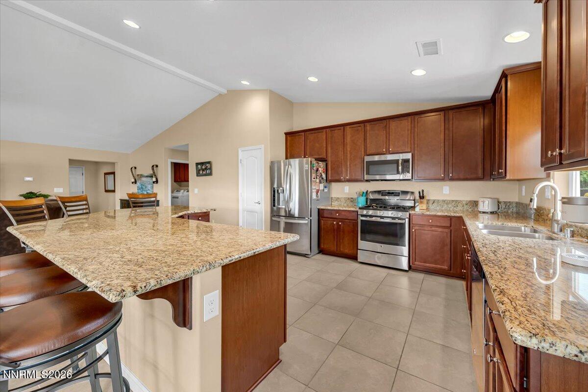 104 Bethpage Road Dayton, NV 89403 - Photo 16 of 65 a kitchen with stainless steel appliances granite countertop a stove top oven a sink a dining table and chairs