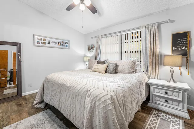 a bedroom with a bed and a lamp on dresser