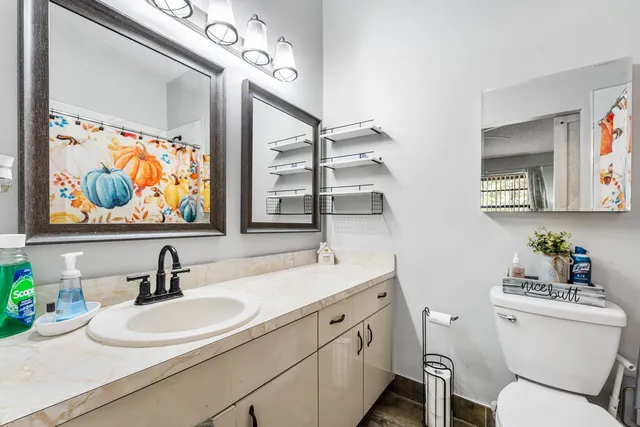 a bathroom with a sink mirror and toilet