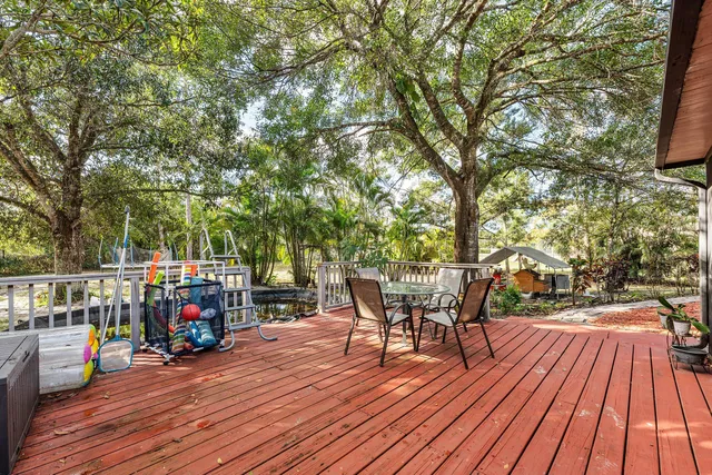 a view of a chairs and table on the wooden deck