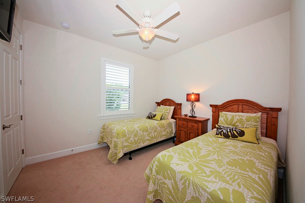10871 Rutherford Road Fort Myers, FL 33913 - Photo 19 of 25 a bedroom with two beds and a chandelier