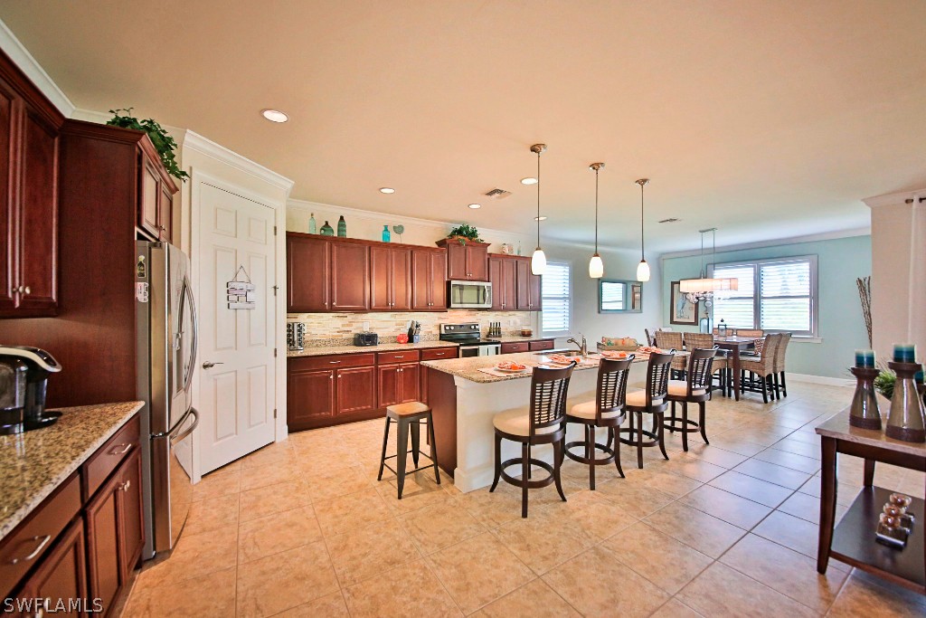 10871 Rutherford Road Fort Myers, FL 33913 - Photo 6 of 25 a large kitchen with lots of counter space dining table and chairs
