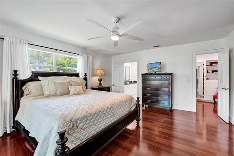 a bedroom with bed and wooden floor
