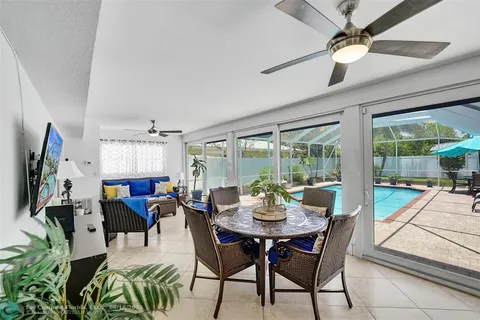 a living room with furniture kitchen view and a large window