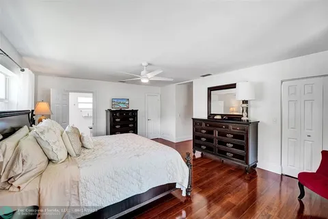a bedroom with bed and wooden floor