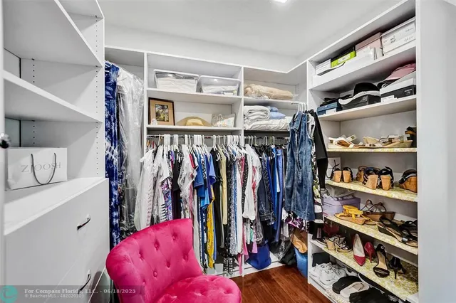 a view of walk in closet with clothes and shoes