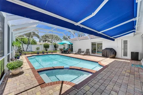 a view of a backyard with swimming pool and furniture