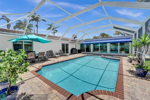 a view of a backyard with swimming pool and furniture