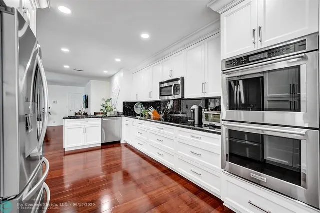 a large white kitchen with stainless steel appliances