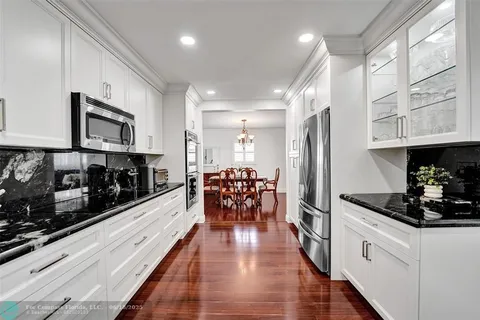 a kitchen with stainless steel appliances kitchen island granite countertop a stove and cabinets