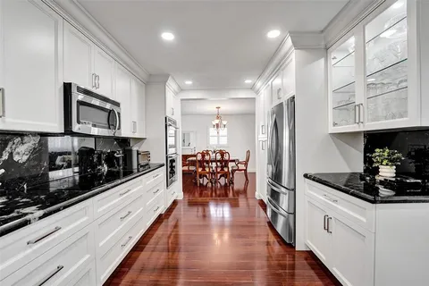 a kitchen with stainless steel appliances kitchen island granite countertop a stove and cabinets
