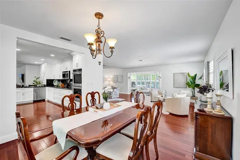 a view of a dining room with furniture a chandelier and wooden floor