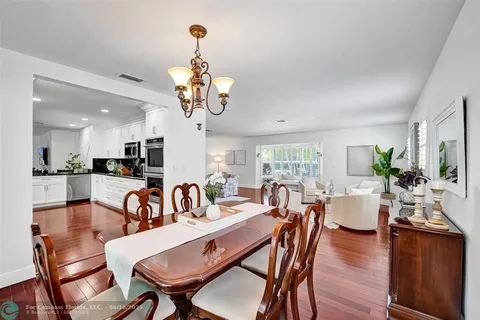 a view of a dining room with furniture a chandelier and wooden floor