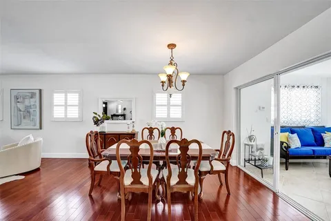 a view of a a dining room with furniture window and wooden floor