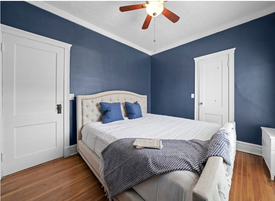 1067 West Balmoral Avenue, Unit 2 Chicago, IL 60640 - Photo 8 of 15 a bedroom with a large bed and a chandelier