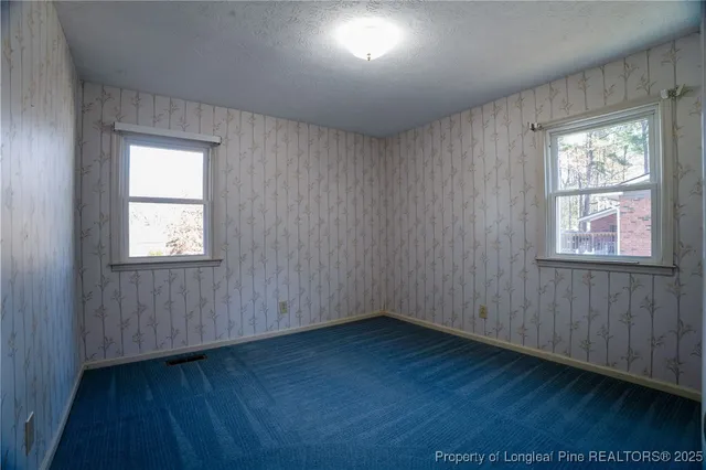 a view of empty room with wooden floor and window