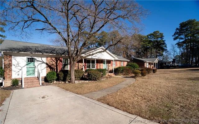 a front view of a house with a yard covered with snow in front of house