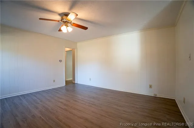 an empty room with closet and a chandelier fan