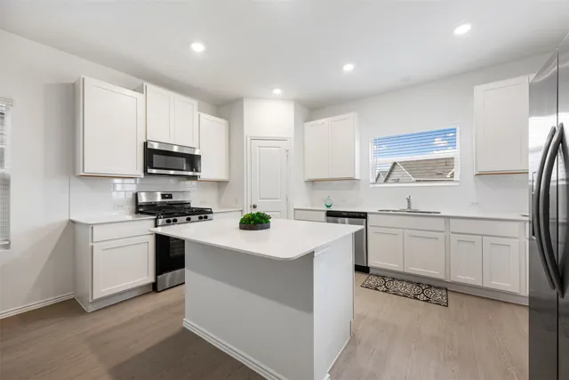 a kitchen with granite countertop white cabinets and white appliances