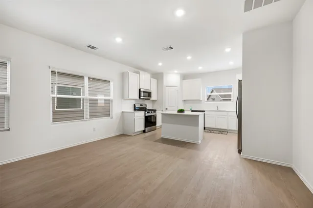 a view of kitchen with wooden floor and electronic appliances
