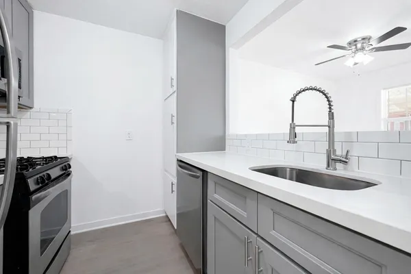 a kitchen with a sink and a stove top oven with wooden floor