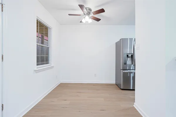 a view of an empty room with closet and a window