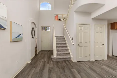 a view of a hallway with wooden floor and staircase