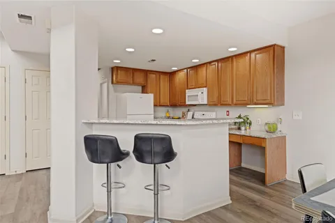 a kitchen with stainless steel appliances granite countertop white cabinets a sink and a stove