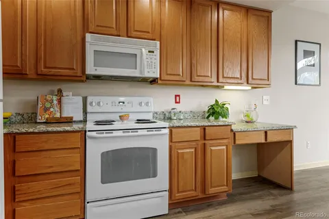 a kitchen with stainless steel appliances granite countertop wooden cabinets sink stove and granite counter top