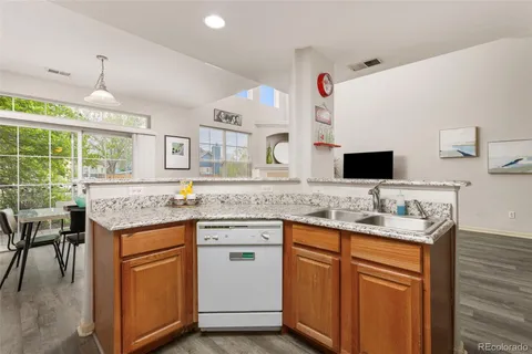 a kitchen with granite countertop cabinets sink and white appliances