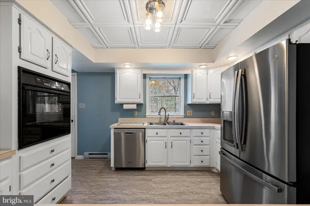 a kitchen with white cabinets and a sink