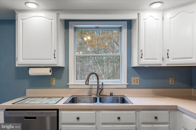 a room with kitchen island granite countertop cabinets and refrigerator