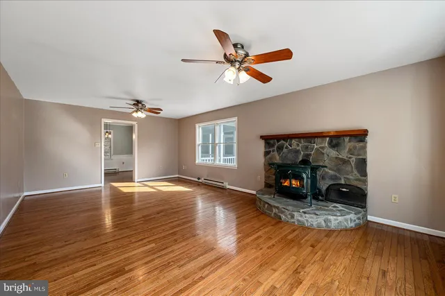 a view of an empty room with window and wooden floor