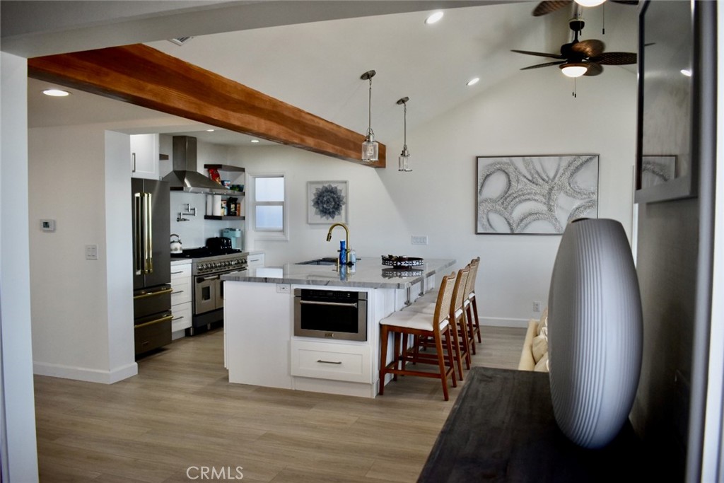35605 Beach Road Dana Point, CA 92624 - Photo 19 of 61 a kitchen with stainless steel appliances granite countertop a refrigerator a stove top oven a dining table and chairs with wooden floor