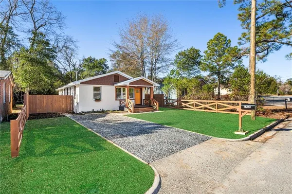a front view of a house with a yard and trees