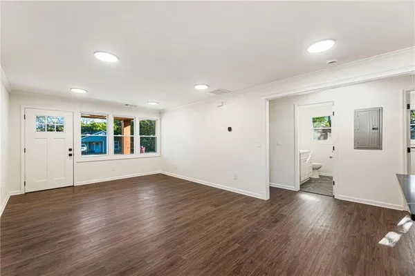 an empty room with wooden floor and windows