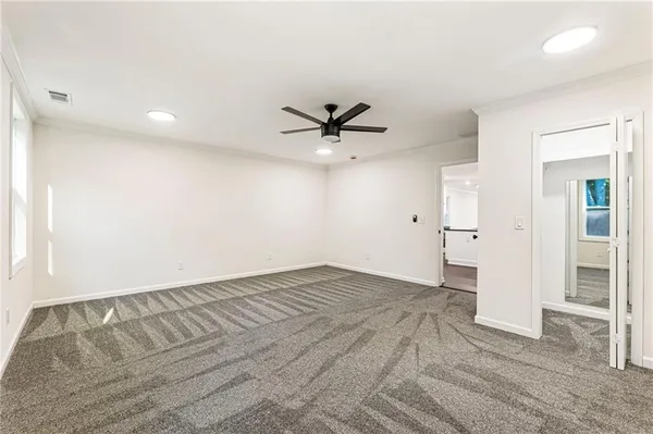 an empty room with wooden floor and ceiling fan