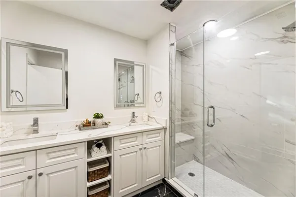 a bathroom with a double vanity sink mirror double and shower