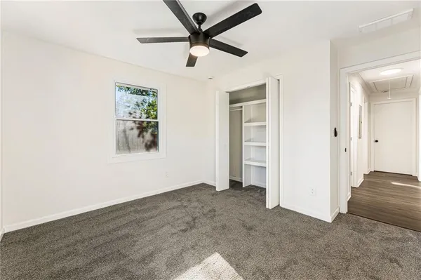 an empty room with a ceiling fan and a window