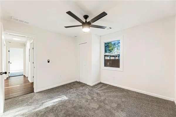 a view of a livingroom with a ceiling fan & window