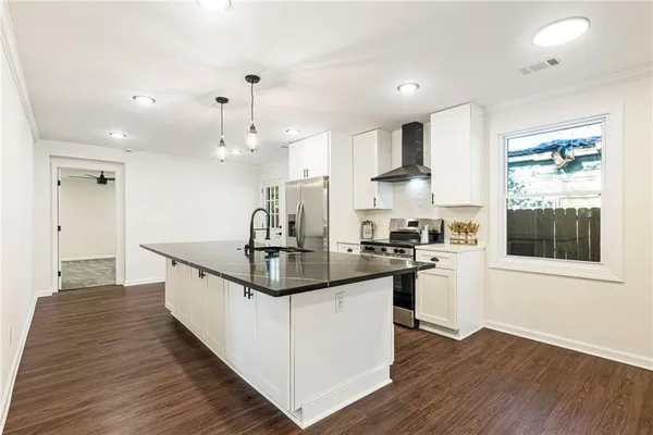 a kitchen with stainless steel appliances granite countertop a sink stove and wooden floor