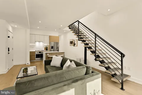 a living room with furniture and a view of kitchen
