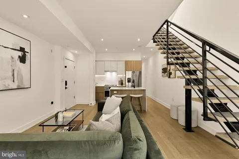 a living room with furniture and kitchen view