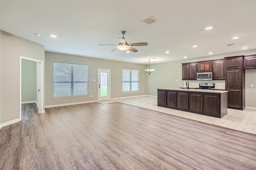 204 West Patton Street Alvarado, TX 76009 - Photo 4 of 17 a large kitchen with stainless steel appliances kitchen island a large counter top a sink and a chandelier
