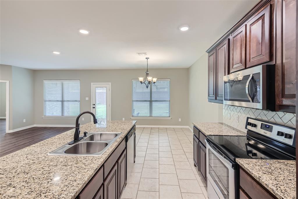 204 West Patton Street Alvarado, TX 76009 - Photo 7 of 17 a kitchen with granite countertop a stove and a sink