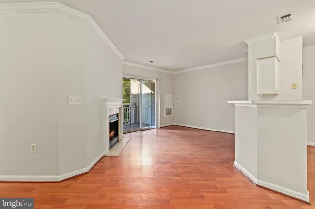 an empty room with wooden floor and fireplace