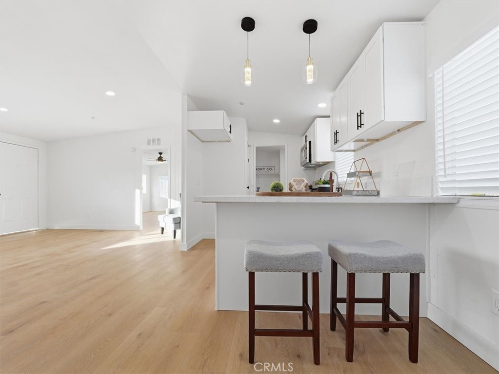 11878 Pacific Road Phelan, CA 92371 - Photo 12 of 50 a kitchen with kitchen island a dining table chairs sink and cabinets