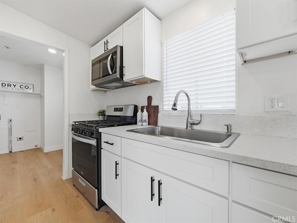 11878 Pacific Road Phelan, CA 92371 - Photo 9 of 50 a kitchen with stainless steel appliances granite countertop white cabinets and a stove top oven